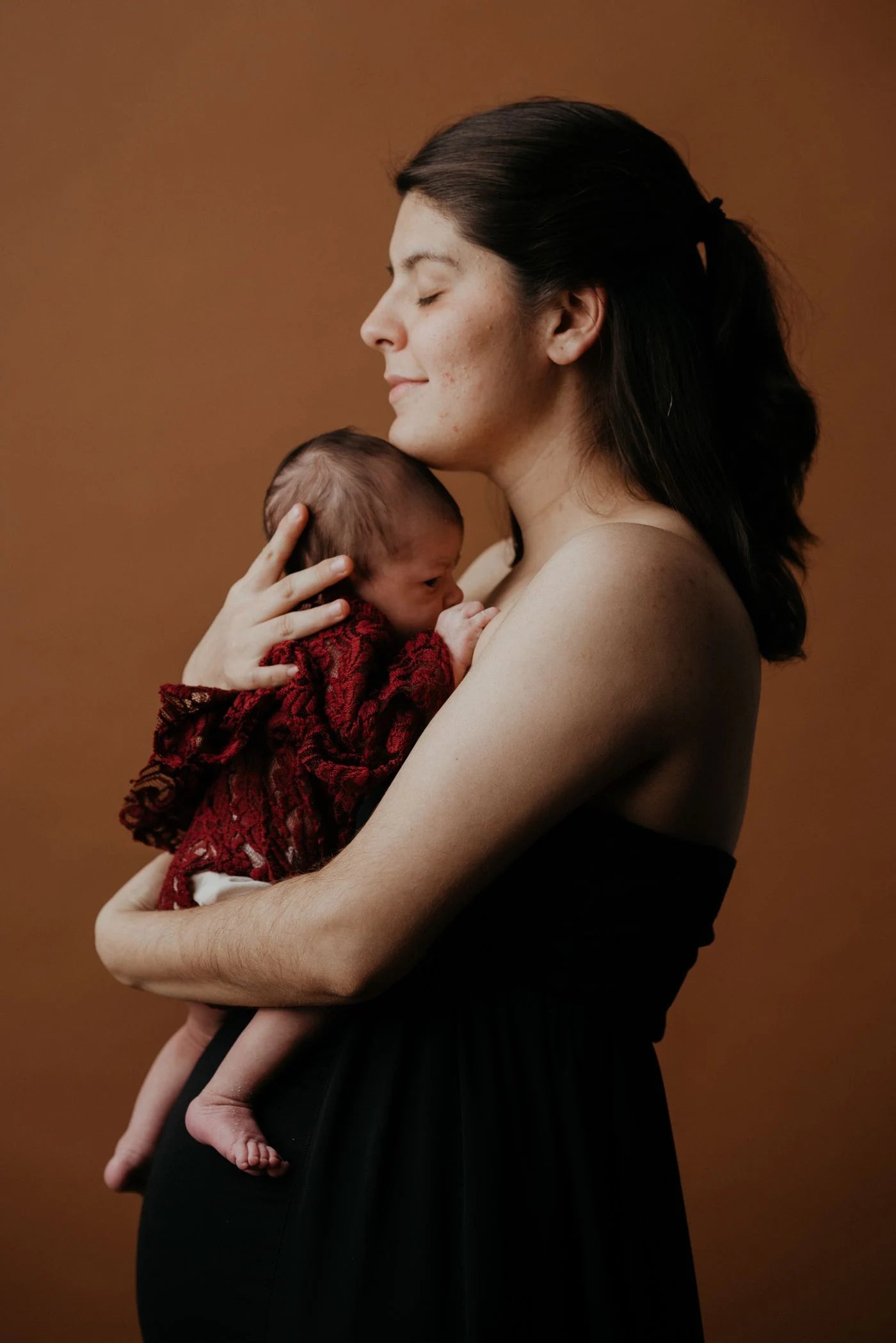 A mother holding her newborn in a warm maternity setting