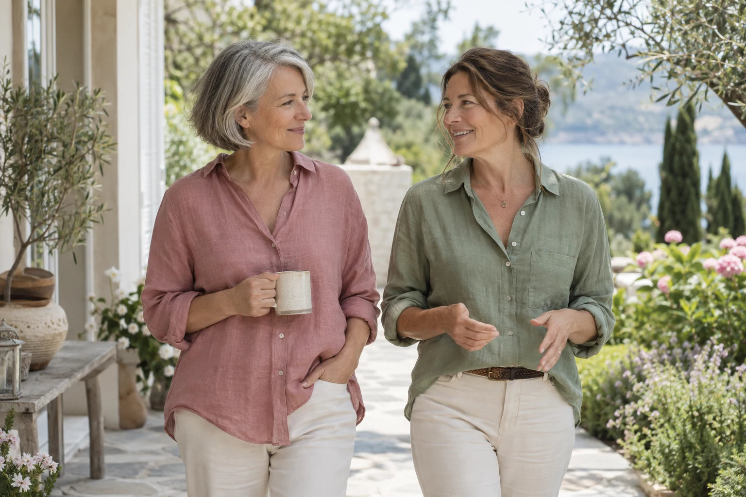 Two mature women in conversation on a bright terrace. Illustrative image.