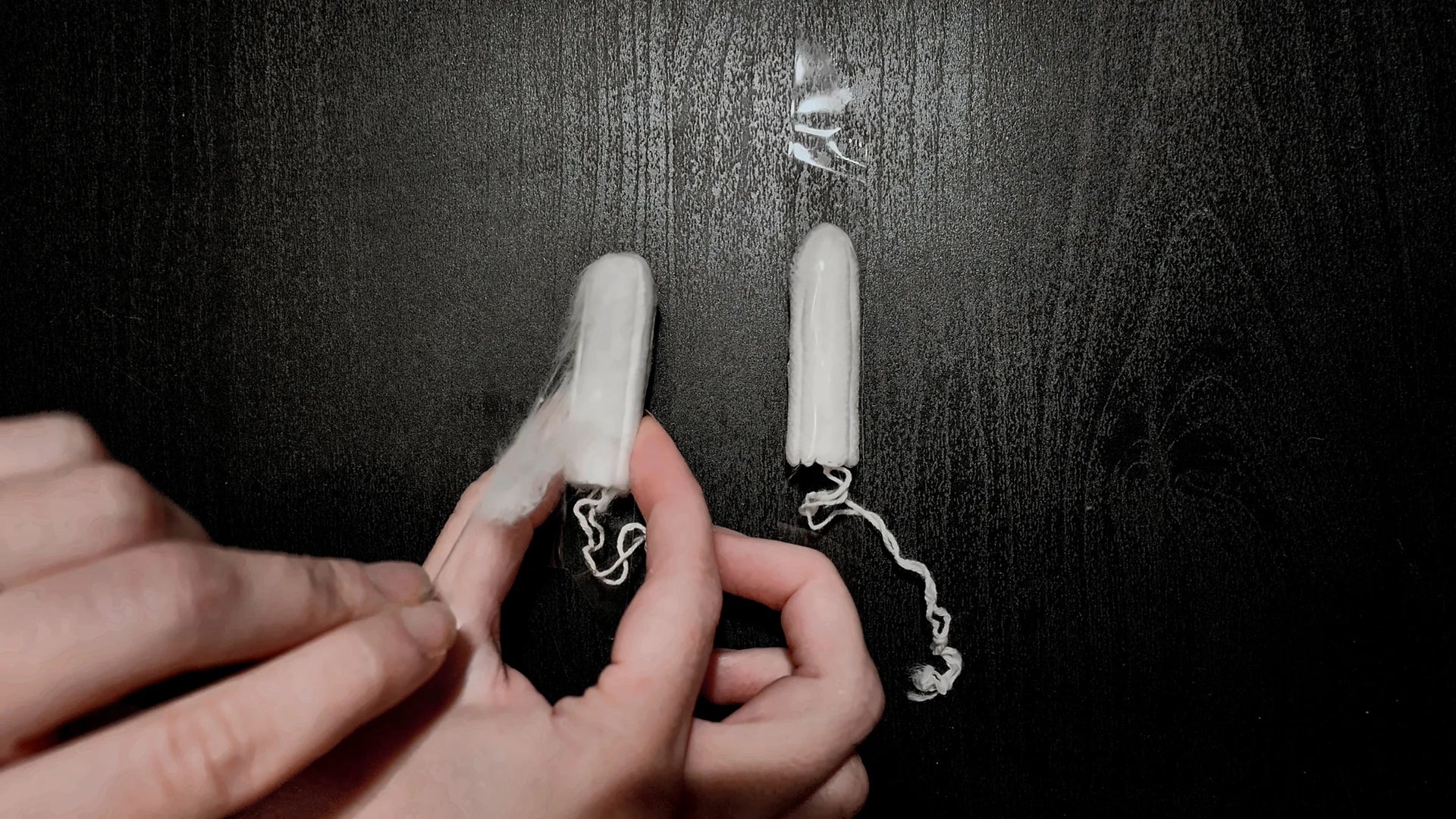 Gently peeling adhesive tape off a tampon.